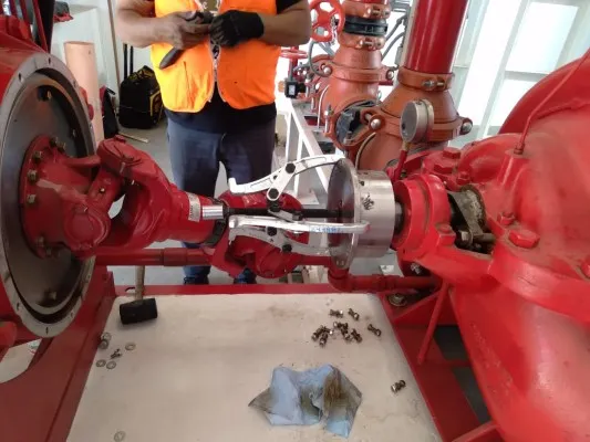Técnico realizando el desmontaje del acoplamiento de una bomba contra incendio siguiendo protocolos NFPA de servicio.