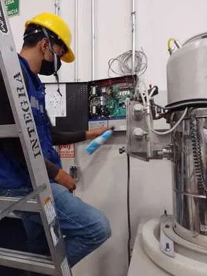 Especialista configurando el panel electrónico que monitorea la presión del hidrante contra incendio en el almacén.