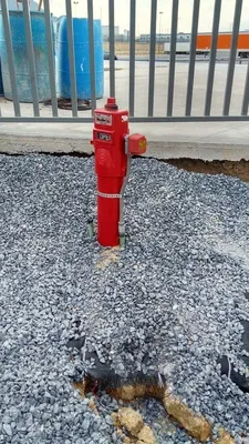 Detalle de sensor de flujo instalado en tubería roja de una red de protección contra incendios en un almacén moderno.
